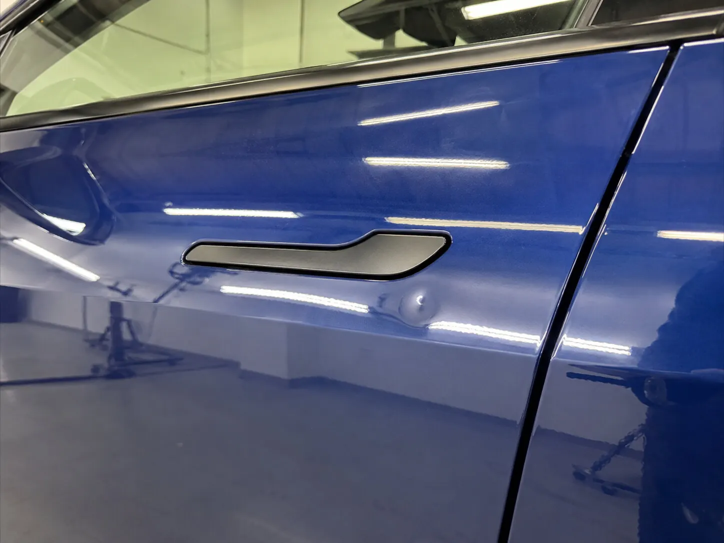 Dent in a Tesla aluminum door before repair
